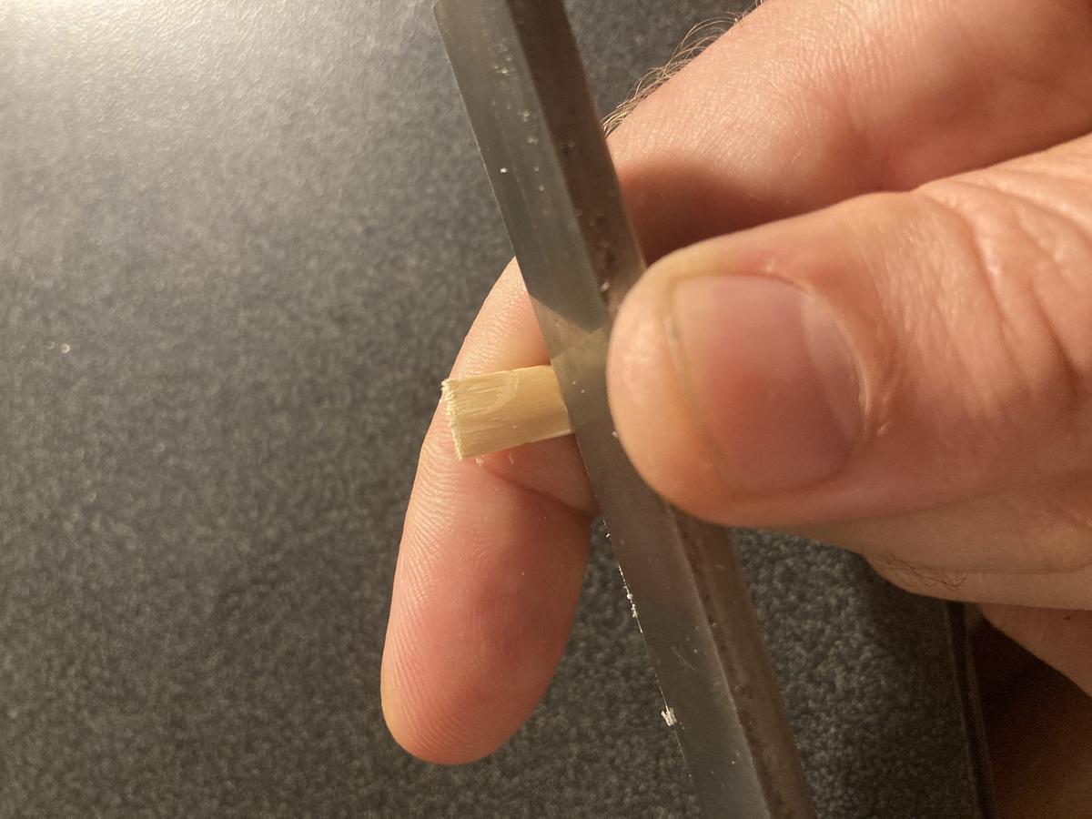 Knife scraping the reed